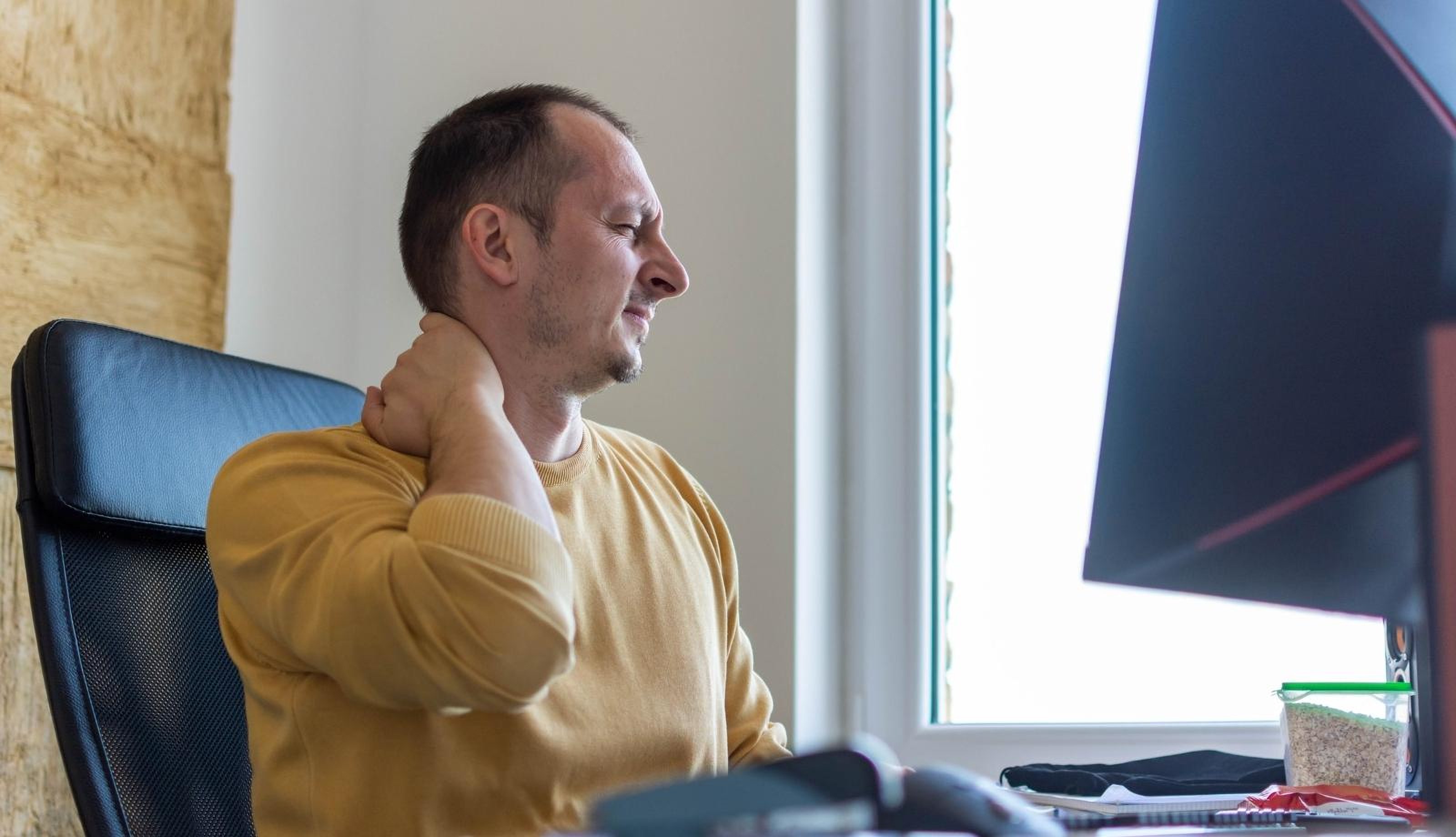 Person sitting peacefully in a bright plant-filled room engaged in self-directed wellness learning